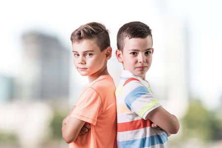 Two happy young boys stand together against the white backgroundの写真素材