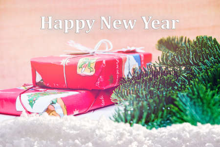 Happy new year. Christmas gifts with fir tree branches on wooden background. Xmas greeting card and border with copy spaceの写真素材
