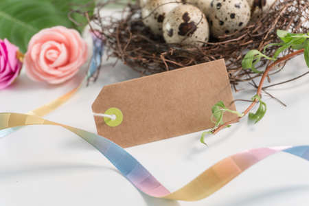 Easter quail Eggs in nest and with greeting card. Basket of easter eggs and decor