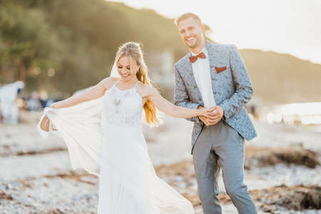 bride and groom walking on the beachの写真素材