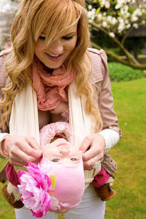 Young mother and baby daughter having fum outdoorsの写真素材