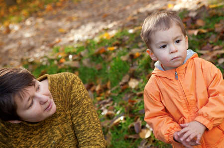 Mother and son in autumn forestの写真素材