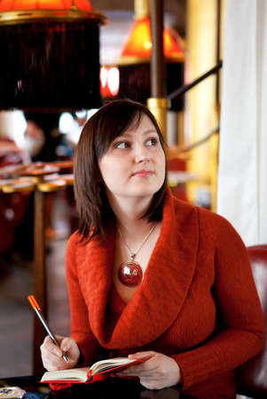 Beautiful girl with her personal organizer in a Parisian cafeの写真素材