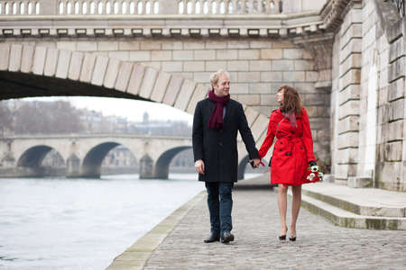 Beautiful romantic couple on a Parisian embankment at spring or winterの写真素材
