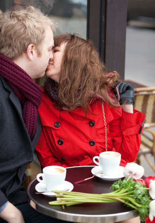 Happy couple kissing in Parisian cafeの写真素材