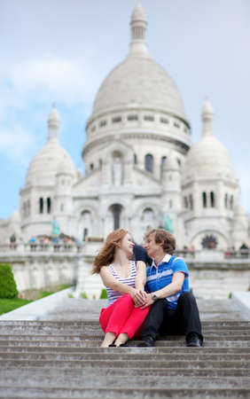 Couple of tourists sitting by the Sacre-Coeur in Parisの写真素材