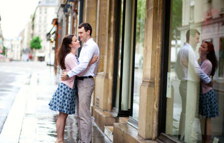 Hugging couple and their reflection in window