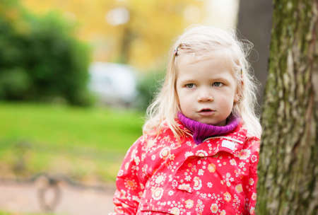 Outdoor autumn portrait of little girl