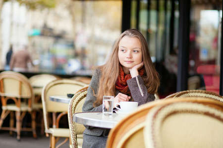 Thoughtful young girl in an outdoor cafe in Parisの写真素材