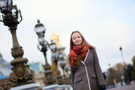Beautiful girl walking on the Pont Alexandre III in Parisの写真素材