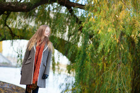 Beautiful young woman near a willow tree