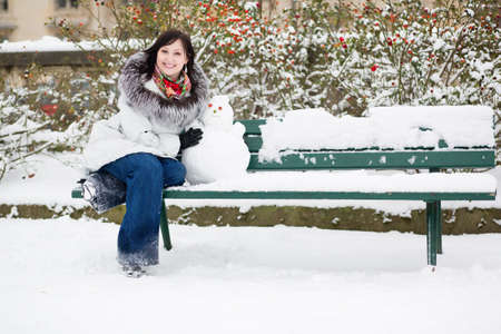 Beautiful smiling girl with a little snowmanの写真素材