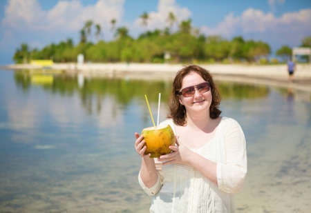 Beautiful woman with coconut on a tropical islandの写真素材