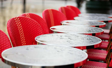 Round tables in a Parisian cafe under the rain
