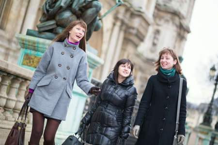Three joyful girls having fun together in Parisの写真素材