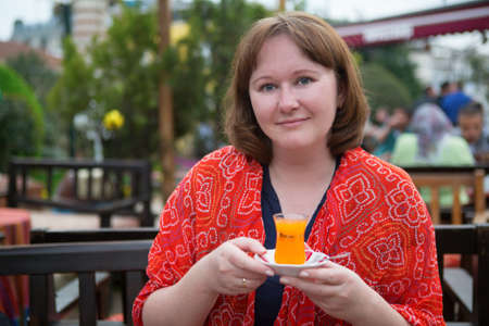 Girl drinking orange tea in Istanbulの写真素材