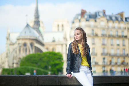 Young beautiful Parisian girl near Notre-Dameの写真素材