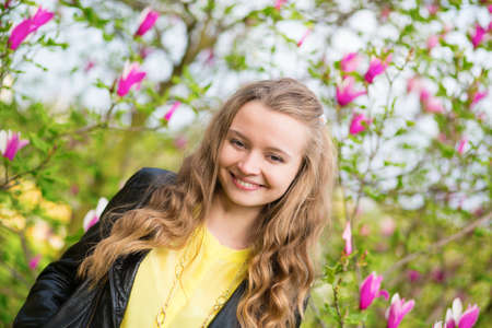 Laughing girl with blooming magnoliaの写真素材