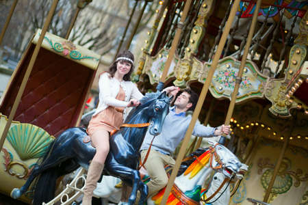 Couple having fun on merry-go-roundの写真素材