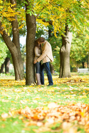 Couple kissing in park on a fall dayの写真素材