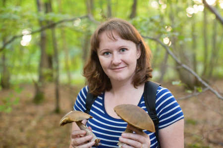 Happy girl with mushrooms in the forestの写真素材