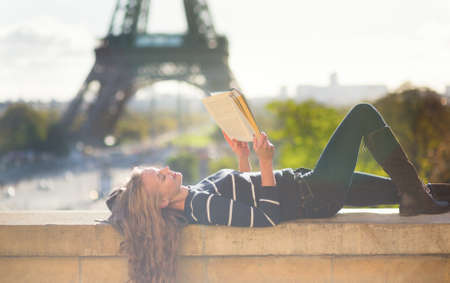 Girl reading a book in Paris on a sunny dayの写真素材