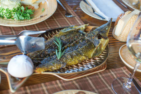 Fried sturgeon served on a plate with garlic and herbs