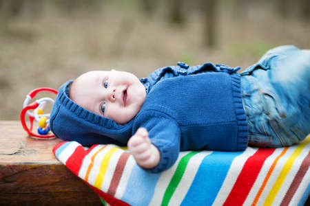 Adorable 4 month baby boy lying on his back and laughingの写真素材