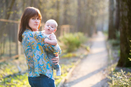 Young mother with her little son in a spring forestの写真素材