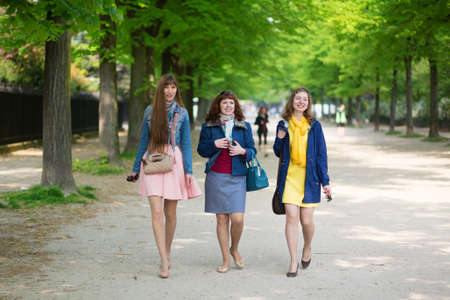 Happy friends walking together in Parisの写真素材