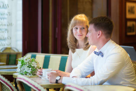Beautiful just married couple drinking coffee in a Parisian cafeの写真素材
