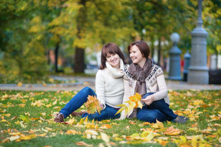 Middle aged woman with adult daughter enjoying beautiful fall dayの写真素材