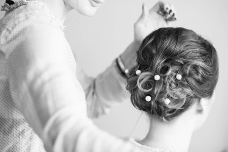 Young bride getting her hair done before wedding