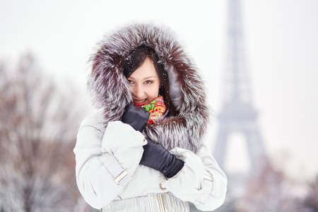 Beautiful young woman enjoying rare snowy winter day in Parisの写真素材