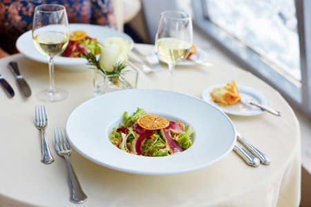 Delicious salad with herbs, smoked duck breast and dry orange