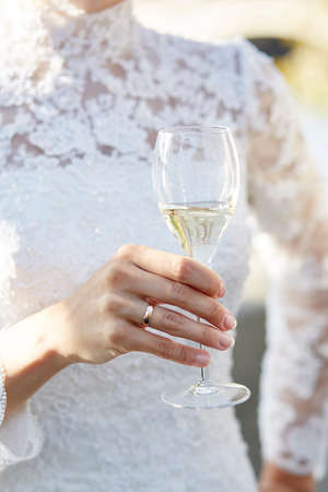Bride holding glass of champagne to celebrate her wedding dayの写真素材