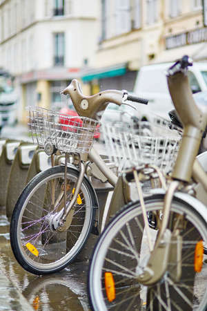Parisian public bicycles under the rainの写真素材