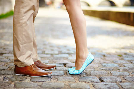 Closeup of male and female legs during a dateの写真素材