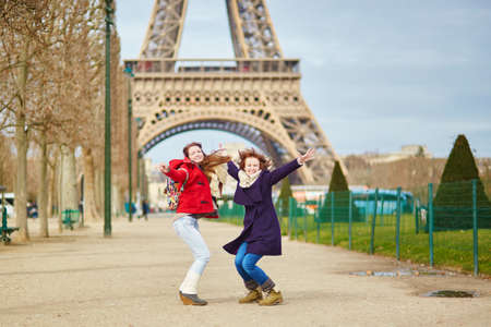 Two beautiful young girls in Paris having fun near the Eiffel towerの写真素材