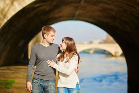 Beautiful romantic couple in Paris walking by the Seineの写真素材