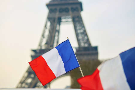 French national flag (tricolour) in Paris with the Eiffel tower in the backgroundの写真素材
