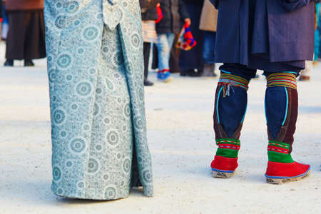 Couple in traditional Tibetan costumes, focus is on the man's legsの写真素材