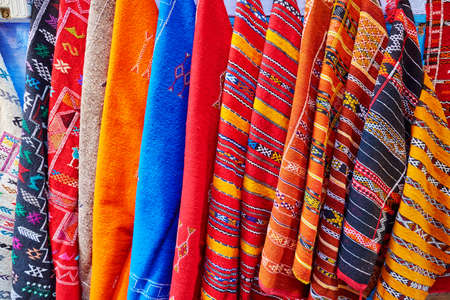 Colorful fabrics and carpets for sale on a street in Medina of Chefchaouen, Morocco
