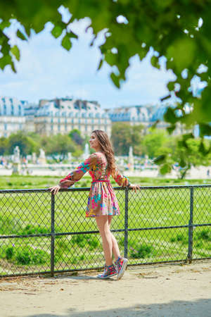 Beautiful young Parisian woman relaxing in the Tuileries garden on a sunny summer dayの写真素材