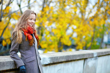 Beautiful young woman in Paris walking on the Isle of the Swans on a beautiful colorful autumn dayの写真素材