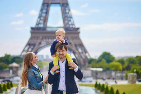 Happy family of three having fun together in Paris near the Eiffel towerの写真素材