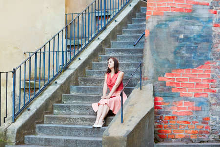 Beautiful young woman sitting on the stairs in Vienna, Austriaの写真素材