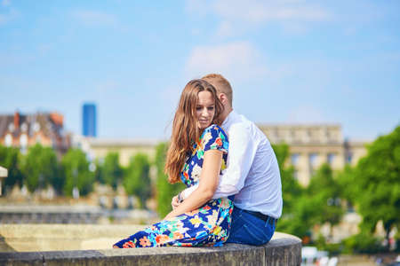 Young romantic couple having a date and hugging on the Seine embankment in Paris, Franceの写真素材