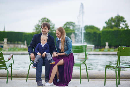Happy family of three in the beautiful garden of Palais Royal in Parisの写真素材