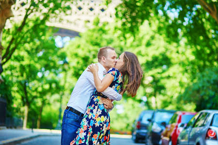 Young romantic couple kissing with passion near the Eiffel tower in Paris, Franceの写真素材